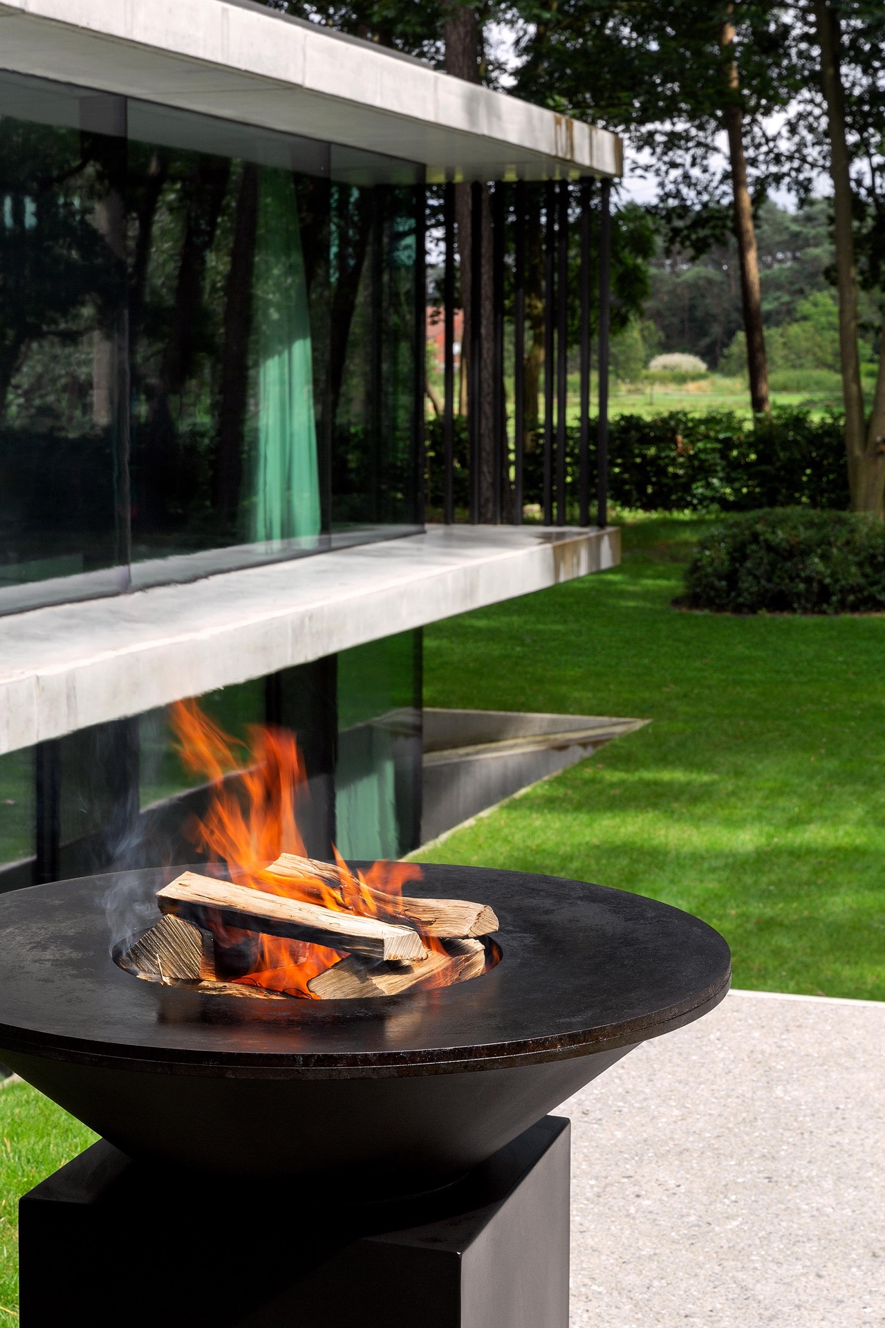 giardino moderno con braciere rotondo e area con acqua: primo piano di un braciere rotondo con fiamme in un giardino moderno, Luxury, Design, Exclusive, Modern, Custom Made, Special, Beautiful