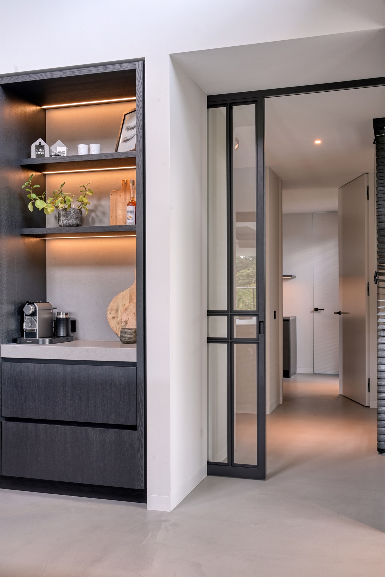 full home interior: side view of kitchen with dark cabinetry wall, open niches and passage to the hall, Luxe, Design, Exclusief, Modern, Maatwerk, Bijzondere, Mooie