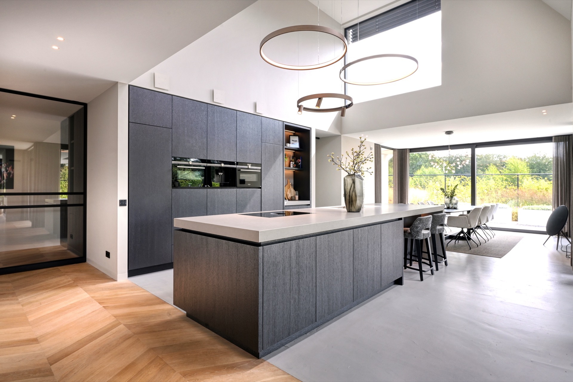 full home interior: modern kitchen with island and sleek dark-grey cabinetry, with warm circular pendant lighting, Luxe, Design, Exclusief, Modern, Maatwerk, Bijzondere, Mooie