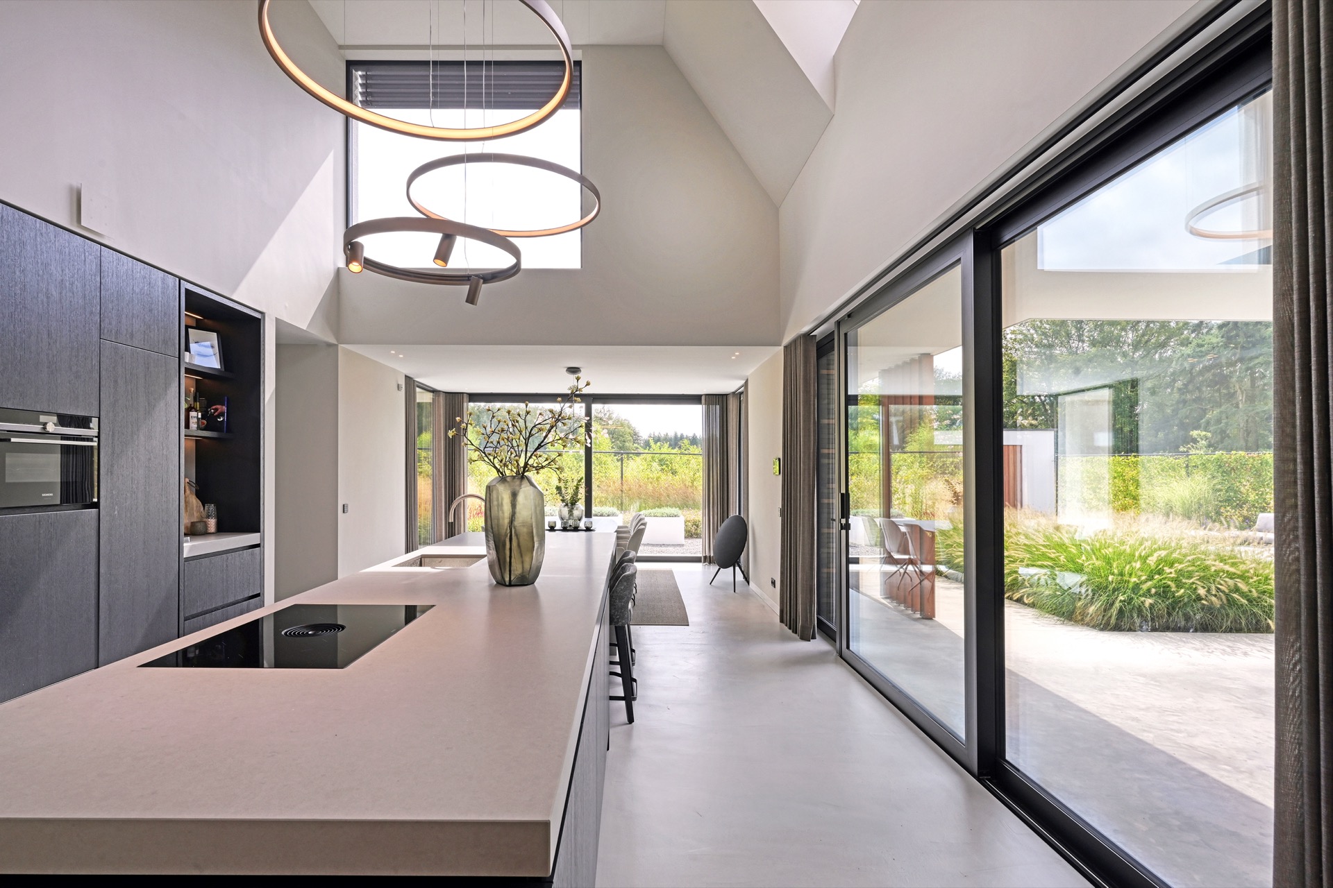 full home interior: kitchen with light island countertop and views toward large glass doors, with round warm pendants, Luxe, Design, Exclusief, Modern, Maatwerk, Bijzondere, Mooie