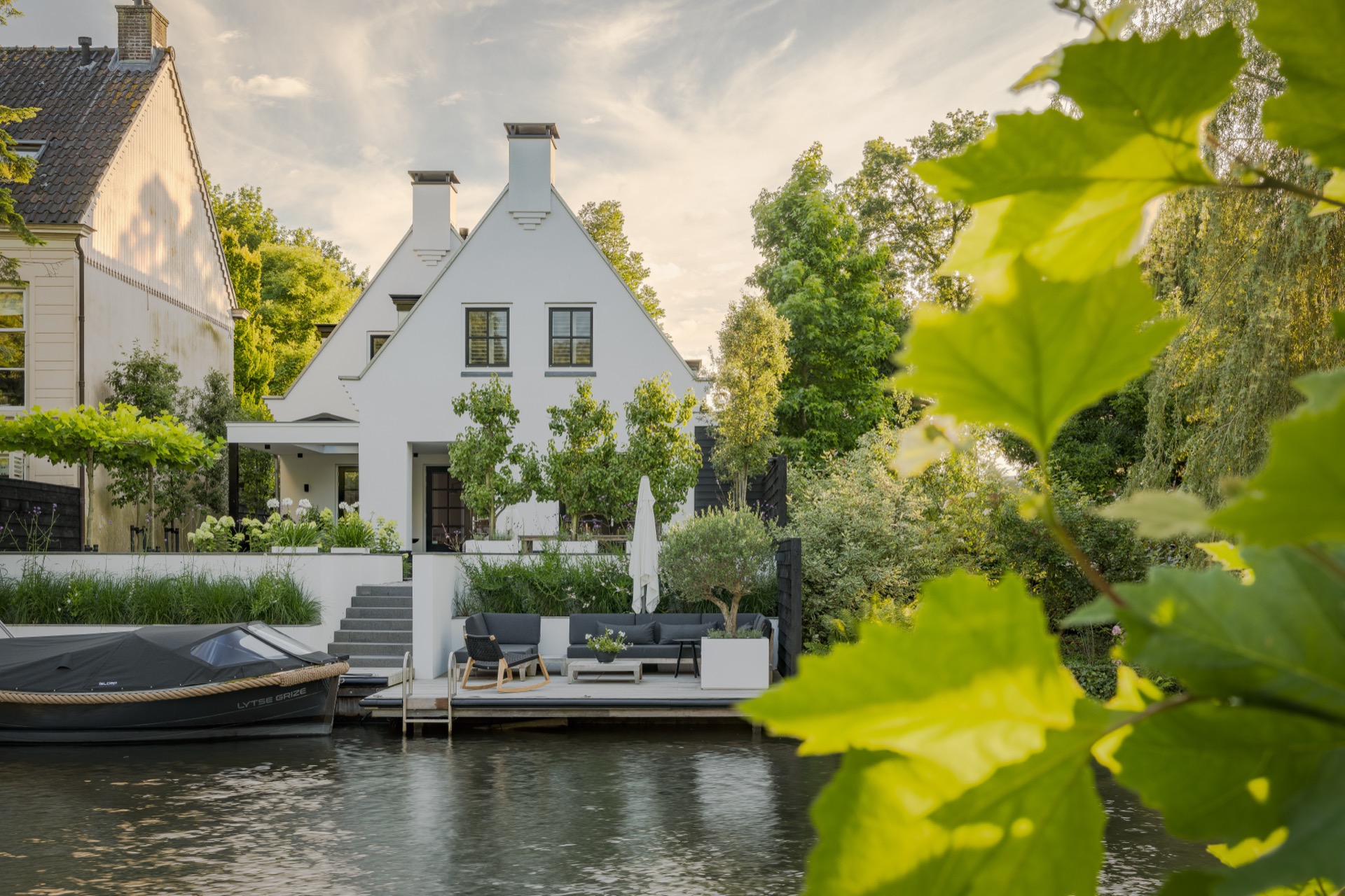 giardino sul bordo dell’acqua: giardino moderno sul lungofiume con terrazza, muro bianco e vegetazione rigogliosa, Luxury, Design, Exclusive, Modern, Custom Made, Special, Beautiful