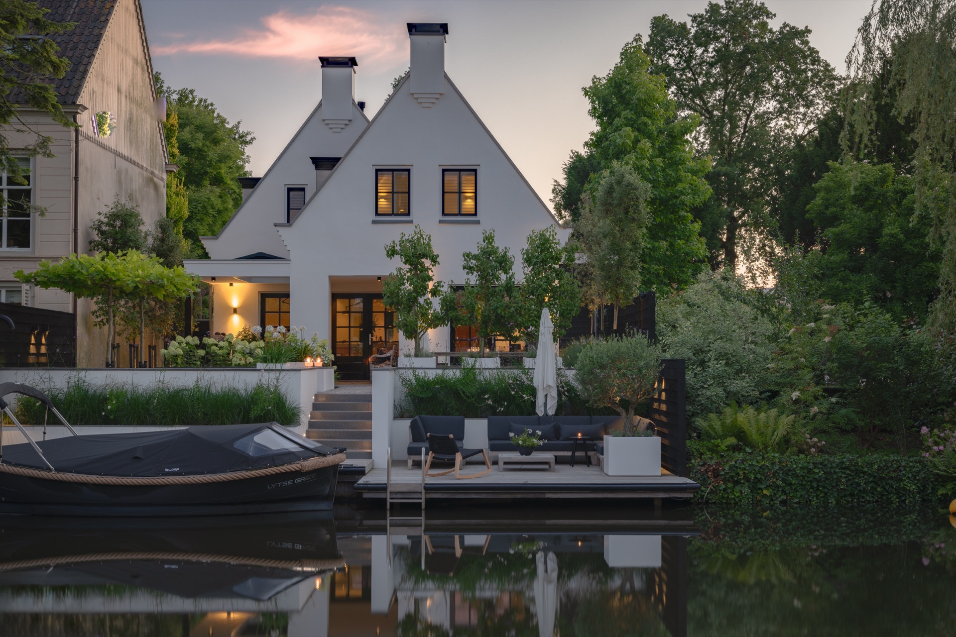 giardino sul bordo dell’acqua: giardino moderno sul bordo dell’acqua con terrazza e vegetazione alla luce serale, Luxury, Design, Exclusive, Modern, Custom Made, Special, Beautiful