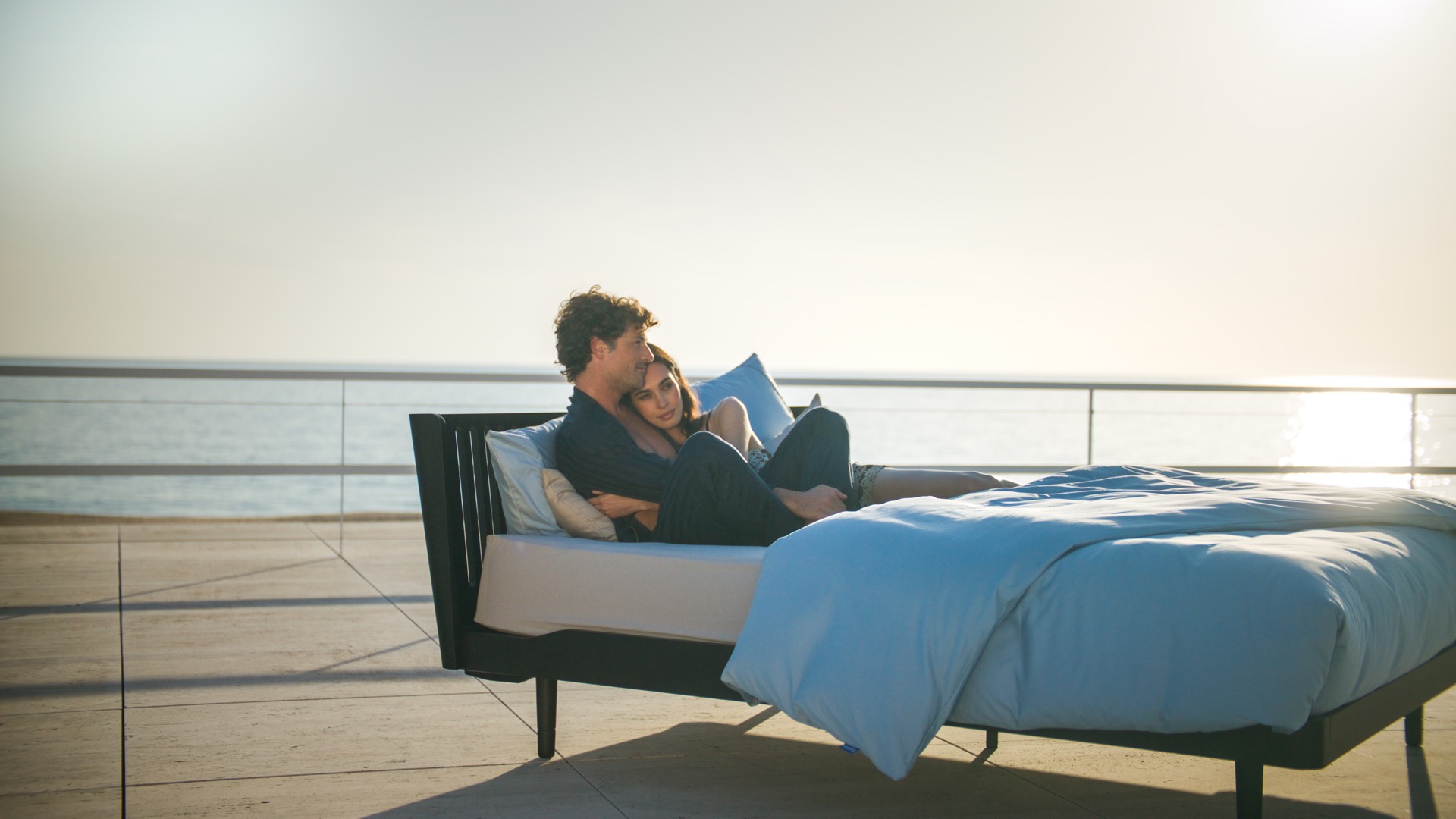 design letto matrimoniale scandinavo: letto moderno scuro su terrazza con vista sul mare, con disposizione di cuscini, Luxury, Design, Exclusive, Modern, Custom Made, Special, Beautiful