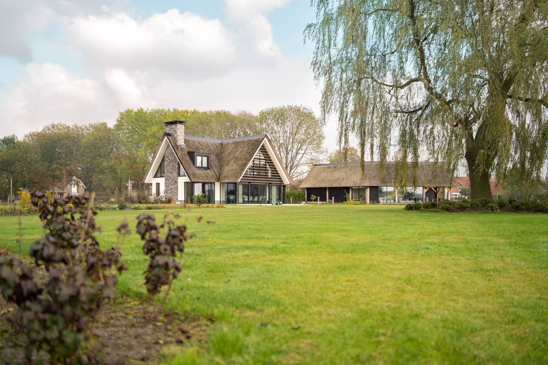 villa rurale con tetto in paglia e grandi vetrate sul retro: dettaglio del tetto in paglia e del camino in pietra su una, Luxury, Design, Exclusive, Modern, Custom Made, Special, Beautiful