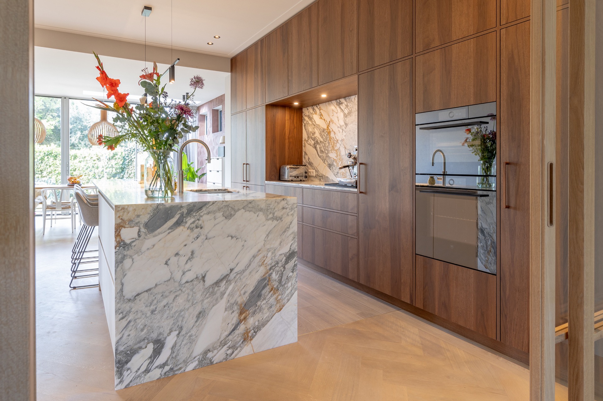 modern kitchen with island and walnut veneer cabinetry: kitchen wall with walnut cabinetry, marble-look backsplash and, Luxe, Design, Exclusief, Modern, Maatwerk, Bijzondere, Mooie