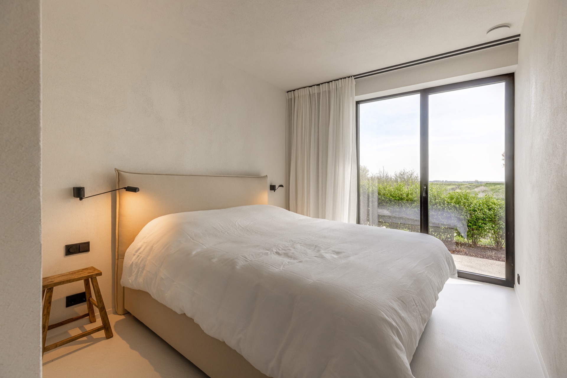 finitura opaca continua in microtopping: camera da letto con grande finestra, letto matrimoniale e pareti opache in interno, Luxury, Design, Exclusive, Modern, Custom Made, Special, Beautiful