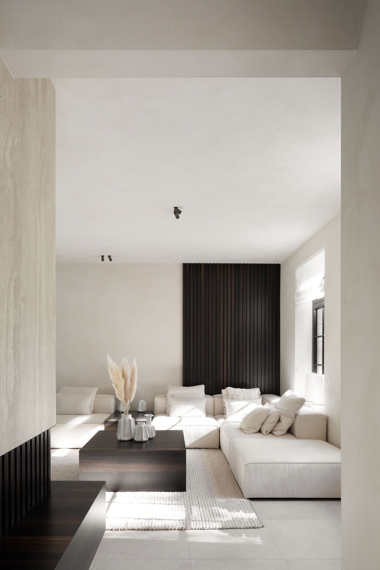 microtopping interno: zona soggiorno con parete a lamelle nere, superfici chiare in intonaco e faretti a soffitto, Luxury, Design, Exclusive, Modern, Custom Made, Special, Beautiful