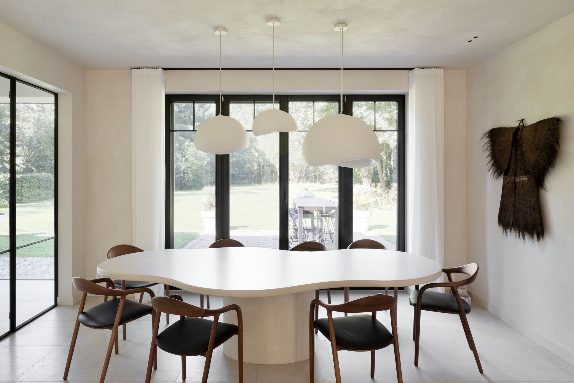 microtopping interno: sala da pranzo con tavolo rotondo e grandi finestre, finitura in intonaco chiaro e luci a sospensione, Luxury, Design, Exclusive, Modern, Custom Made, Special, Beautiful