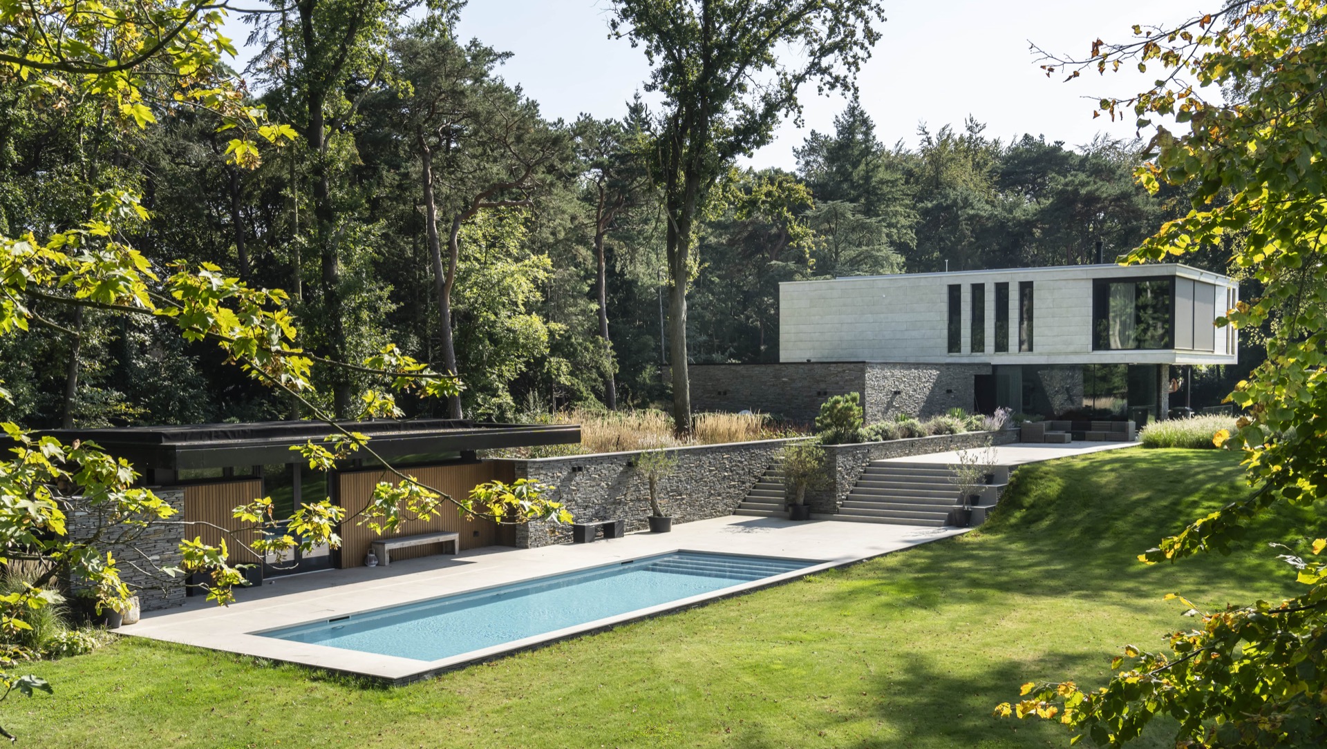 piscina skimmer rivestimento grigio chiaro: piscina con terrazza e gradini in pietra naturale, casa moderna tra alberi nel, Luxury, Design, Exclusive, Modern, Custom Made, Special, Beautiful
