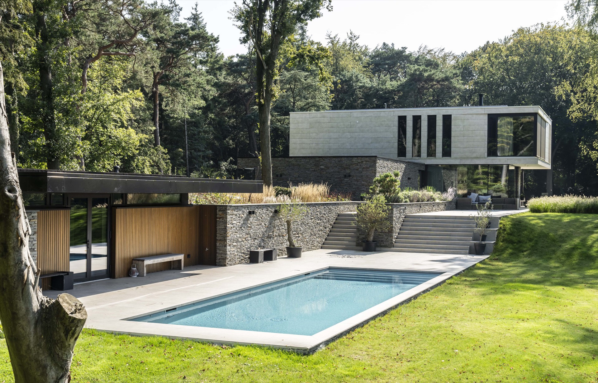 piscina skimmer rivestimento grigio chiaro: piscina con skimmer moderna con terrazza, muretto in pietra naturale e casa, Luxury, Design, Exclusive, Modern, Custom Made, Special, Beautiful