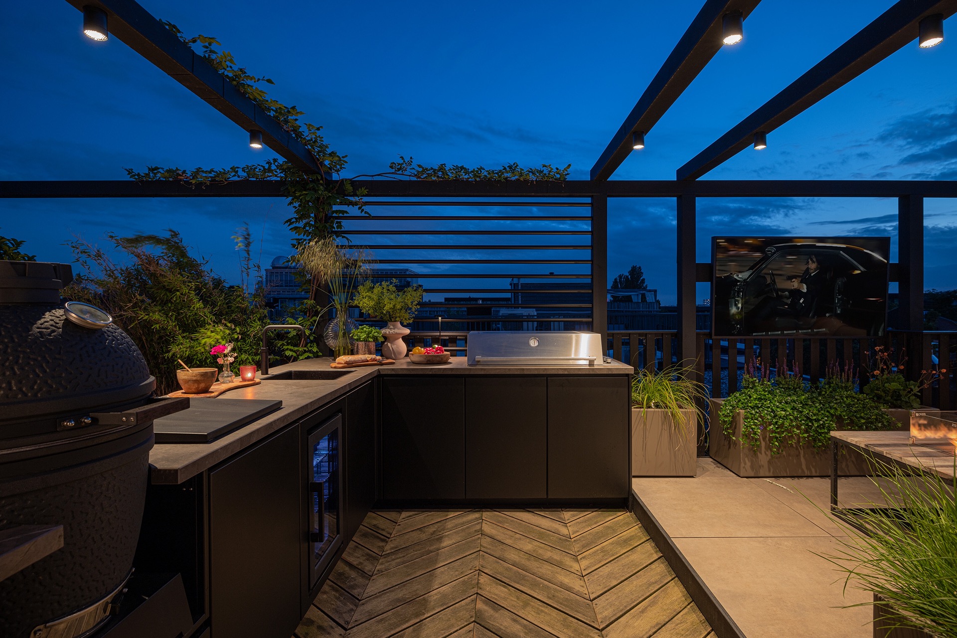 terrazza sul tetto di lusso con cucina esterna e tavolo fuoco: bordo con vegetazione e grande fioriera rotonda con luce, Luxury, Design, Exclusive, Modern, Custom Made, Special, Beautiful