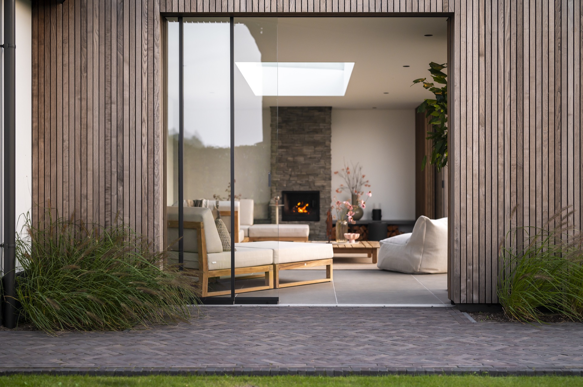 camera esterna con lucernario: vista attraverso pannelli in legno verso l’area salotto e il camino in pietra, Luxury, Design, Exclusive, Modern, Custom Made, Special, Beautiful