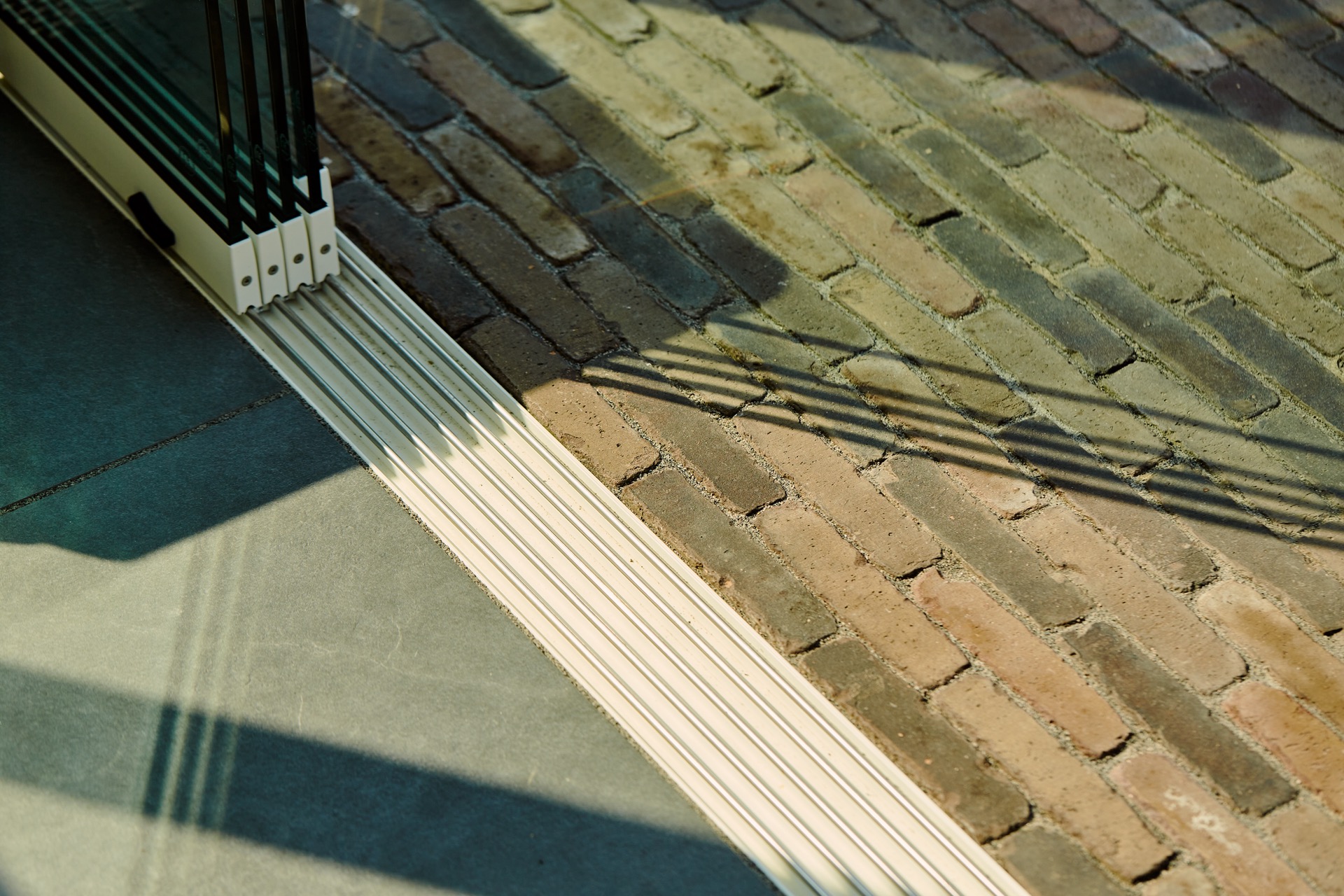outdoor room sliding glass: close-up of a metal rail along a tiled floor near the outdoor room, Luxury, Design, Exclusive, Modern, Custom Made, Special, Beautiful