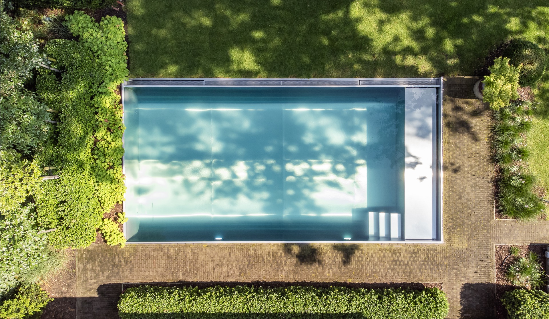 piscina rettangolare moderna: dettaglio del bordo in acciaio inox con griglia e acqua blu accanto al prato, Luxury, Design, Exclusive, Modern, Custom Made, Special, Beautiful