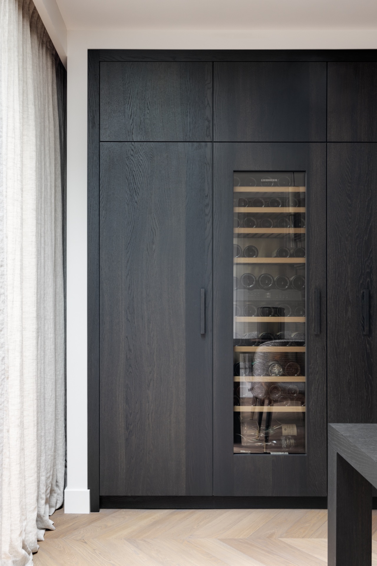 cucina in rovere con isola: dettaglio della cantinetta climatizzata in un mobile su misura scuro con porta in vetro, Luxury, Design, Exclusive, Modern, Custom Made, Special, Beautiful