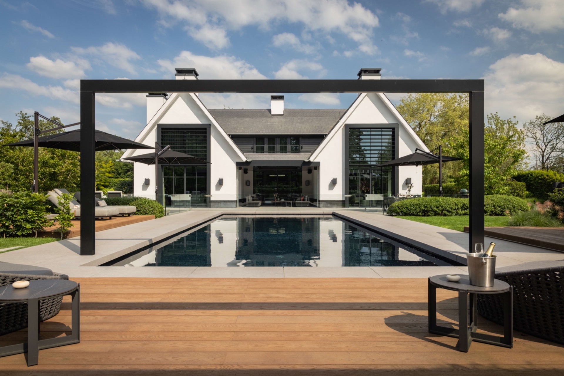 giardino simmetrico con piscina: piscina e terrazza simmetriche davanti a una villa moderna con montanti neri della pergola, Luxury, Design, Exclusive, Modern, Custom Made, Special, Beautiful