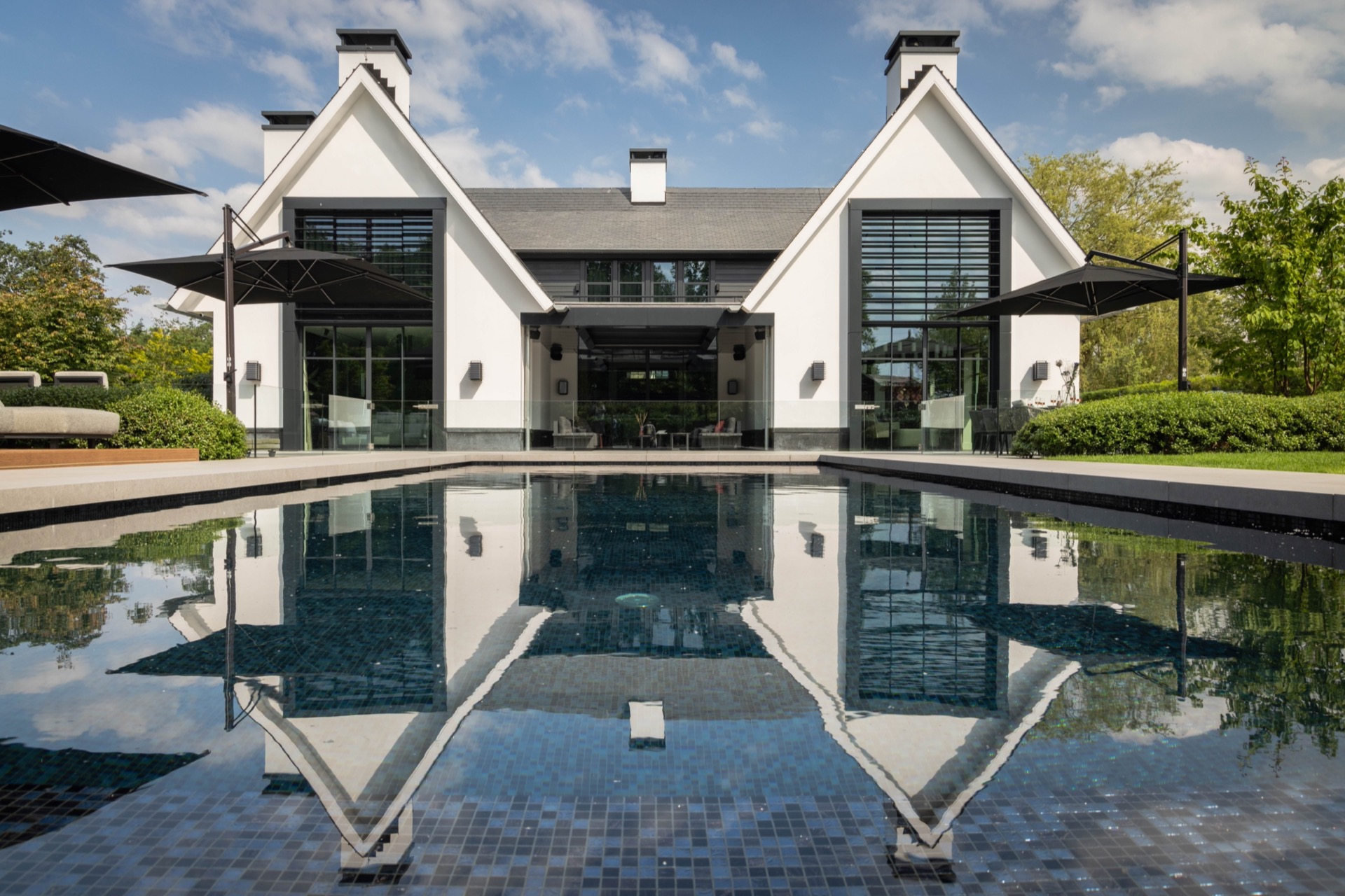 giardino simmetrico con piscina: vista rettilinea su piscina a mosaico verso la villa moderna, fondo piastrellato e riflessi, Luxury, Design, Exclusive, Modern, Custom Made, Special, Beautiful