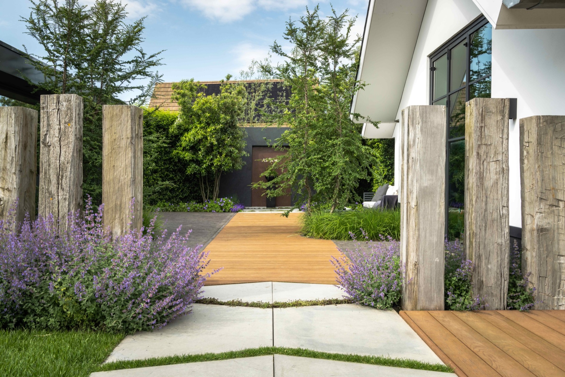 giardino simmetrico con piscina: percorso in giardino tra recinzione in legno e bordure con fiori viola verso la terrazza, Luxury, Design, Exclusive, Modern, Custom Made, Special, Beautiful