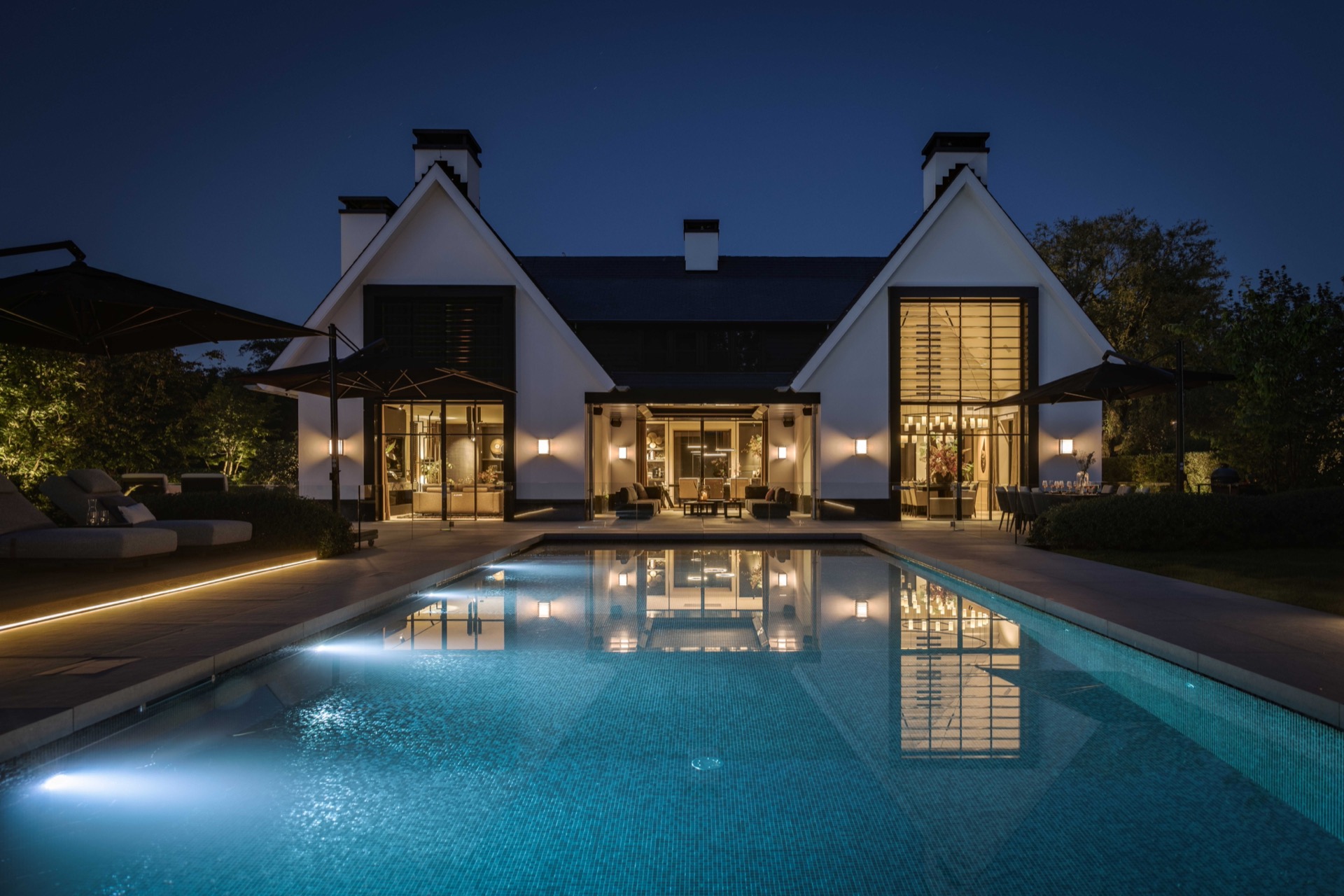 giardino simmetrico con piscina: vista notturna di villa e piscina illuminata con riflessi nell’acqua, Luxury, Design, Exclusive, Modern, Custom Made, Special, Beautiful