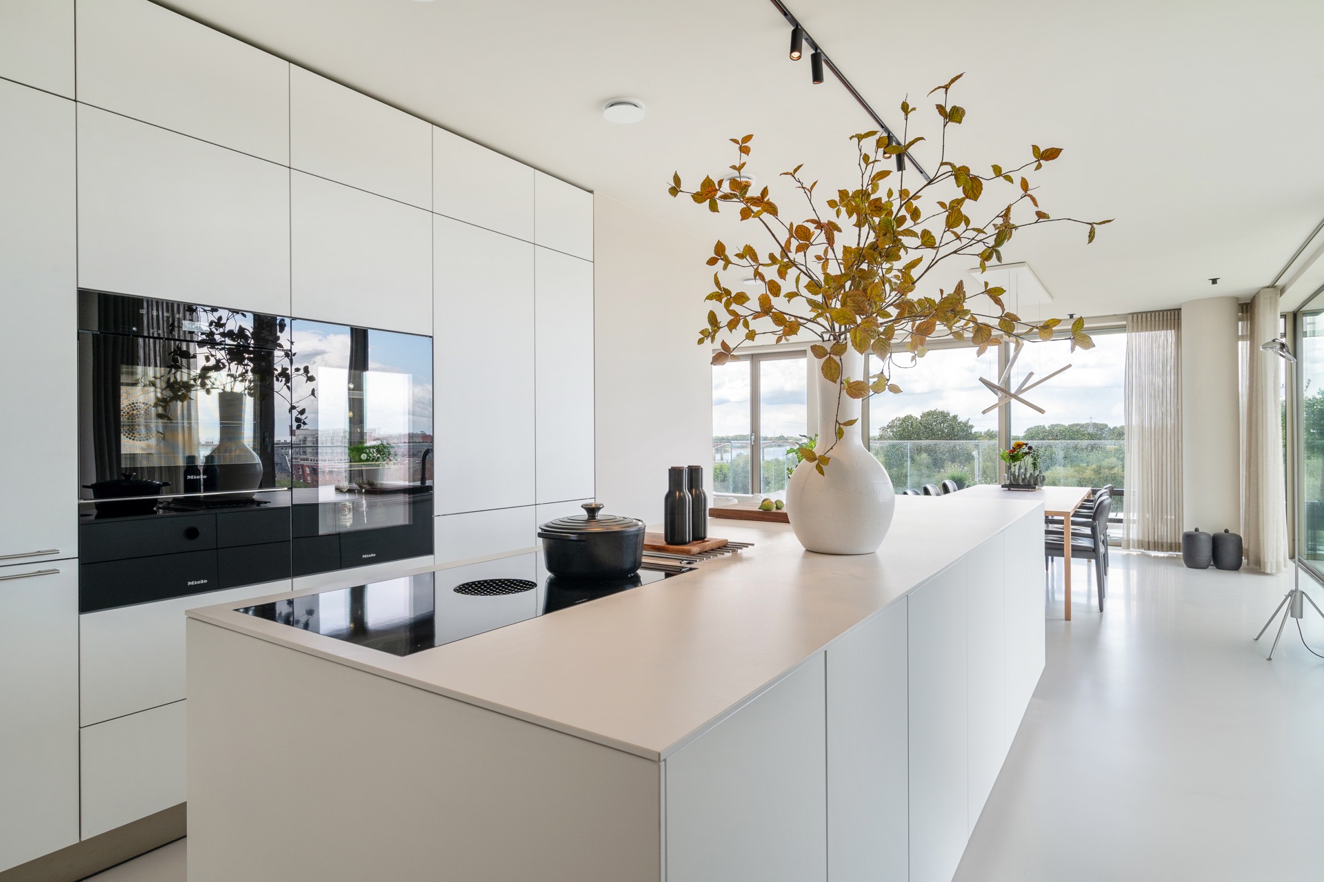 modern new-build kitchen island: modern kitchen wall with tall white cabinets, cooktop zone and black track lighting, Luxe, Design, Exclusief, Modern, Maatwerk, Bijzondere, Mooie