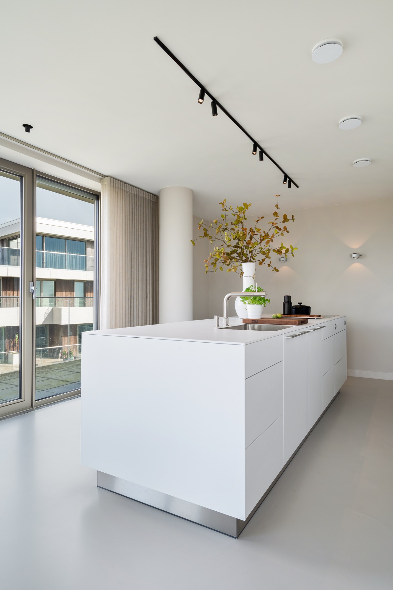 modern new-build kitchen island: detail view of a white kitchen island with track lighting and large windows for daylight, Luxe, Design, Exclusief, Modern, Maatwerk, Bijzondere, Mooie