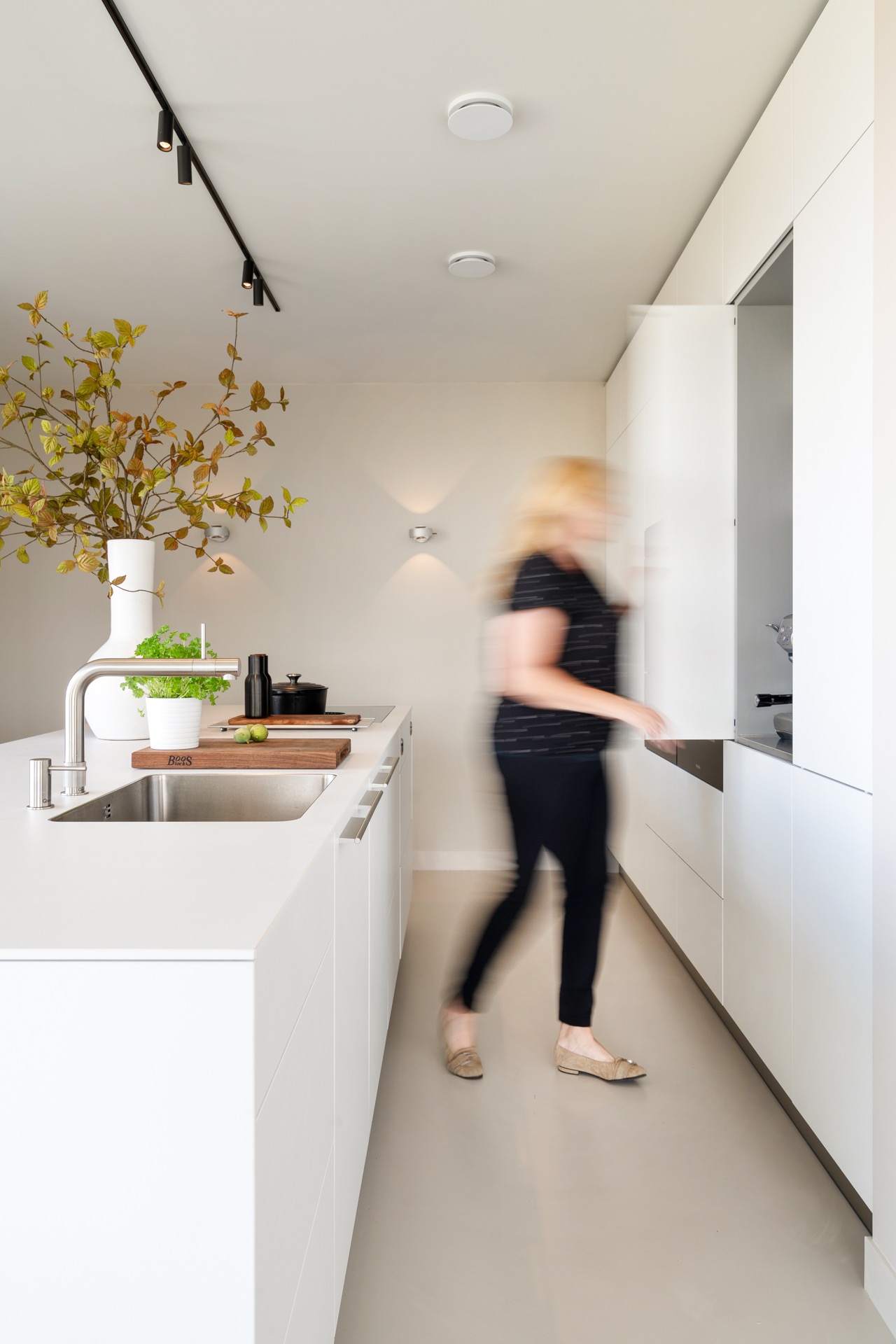 modern new-build kitchen island: atmospheric view of a modern kitchen with white cabinetry and track lighting above the, Luxe, Design, Exclusief, Modern, Maatwerk, Bijzondere, Mooie