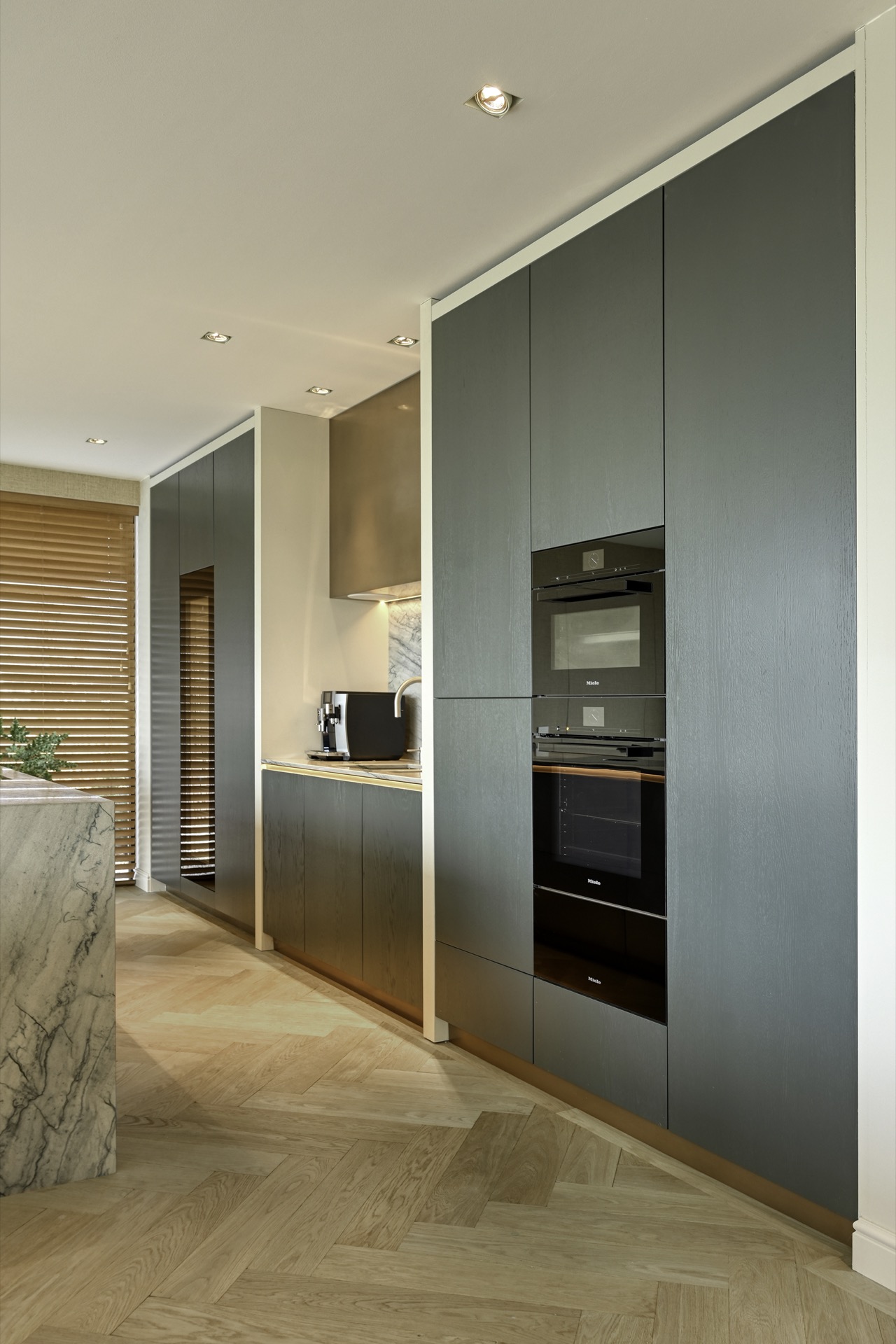 cucina su misura in rovere con isola in pietra: dettaglio del bordo dell’isola in marmo con luce calda dal basso in cucina, Luxury, Design, Exclusive, Modern, Custom Made, Special, Beautiful