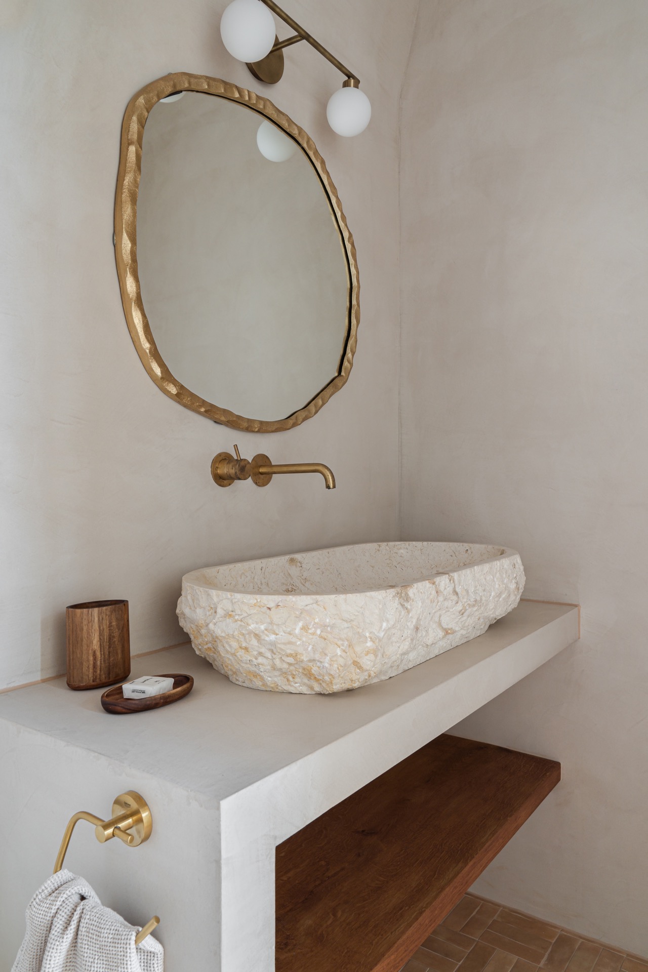 materiali naturali: bagno con specchio rotondo e lavabo dall'aspetto pietra, dettagli metallici caldi., Luxury, Design, Exclusive, Modern, Custom Made, Special, Beautiful