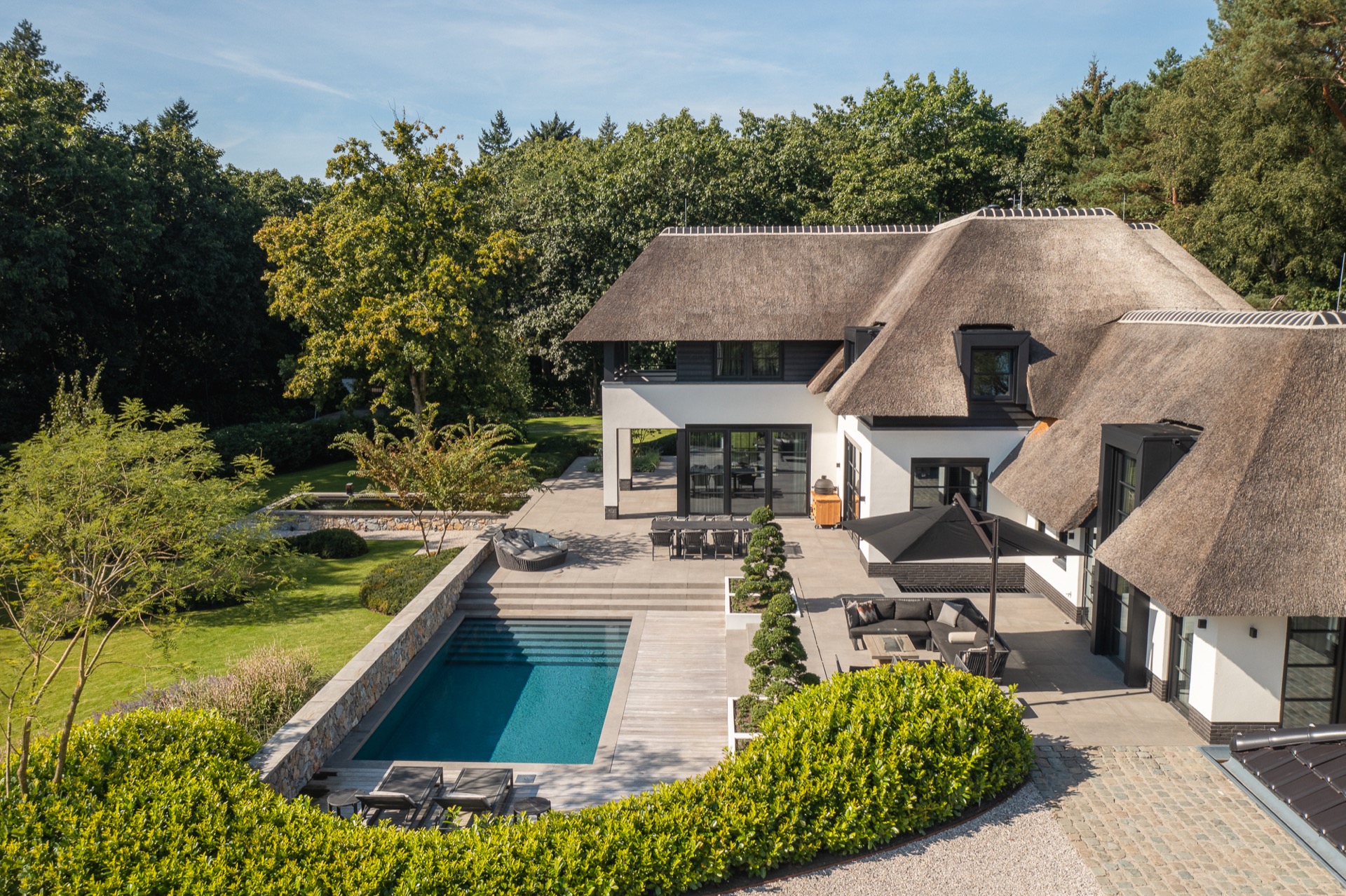 villa da sogno con tetto di paglia: giardino con piscina e patio circondato da alberi e vegetazione in una giornata, Luxury, Design, Exclusive, Modern, Custom Made, Special, Beautiful