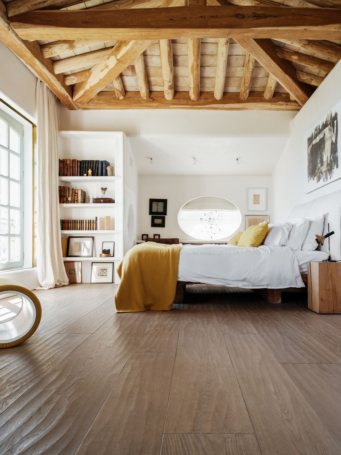 materiali naturali casa: camera da letto con grande letto, travi di legno e finestra rotonda, Luxury, Design, Exclusive, Modern, Custom Made, Special, Beautiful