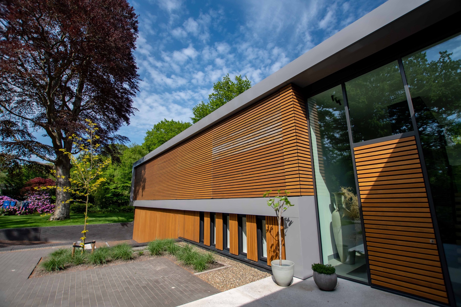 finitura moderna in legno e vetro: edificio moderno con lamelle di legno e grandi finestre, circondato dalla natura, Luxury, Design, Exclusive, Modern, Custom Made, Special, Beautiful