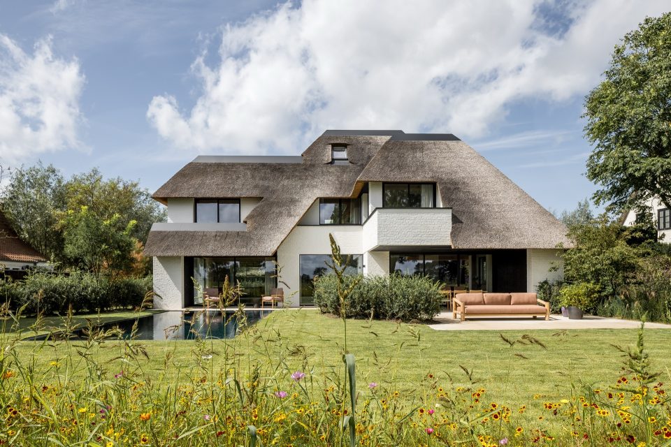luxus villa: verticale houten gevelbekleding: thatched roof: modern house facade with garden and swimming pool