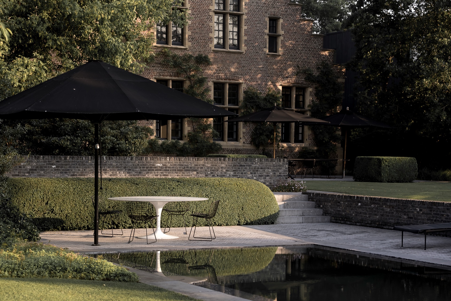 giardino rurale: tavolo con due sedie sotto ombrellone nero nel giardino, Luxury, Design, Exclusive, Modern, Custom Made, Special, Beautiful
