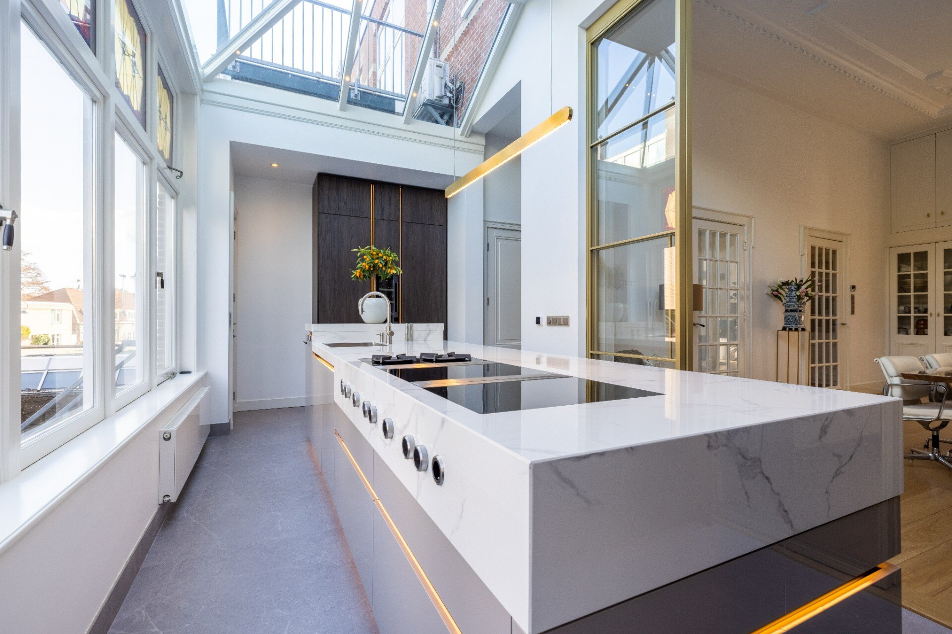 cucina moderna piano marmo: isola cucina lunga con piano lavoro in marmo bianco e armadi alti color legno in cucina luminosa, Luxe, Design, Exclusief, Modern, Maatwerk, Bijzondere, Mooie
