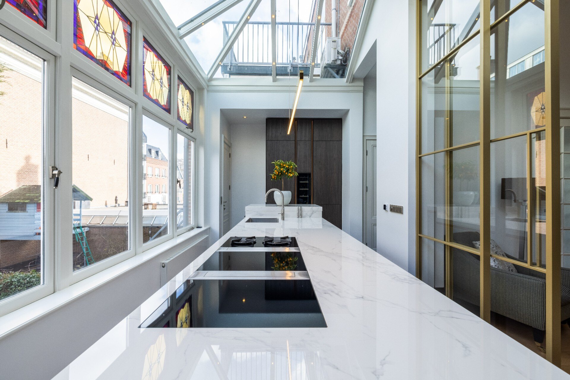 cucina moderna piano marmo: primo piano di mobili da cucina grigi lucidi con illuminazione LED calda e piano in marmo, Luxe, Design, Exclusief, Modern, Maatwerk, Bijzondere, Mooie