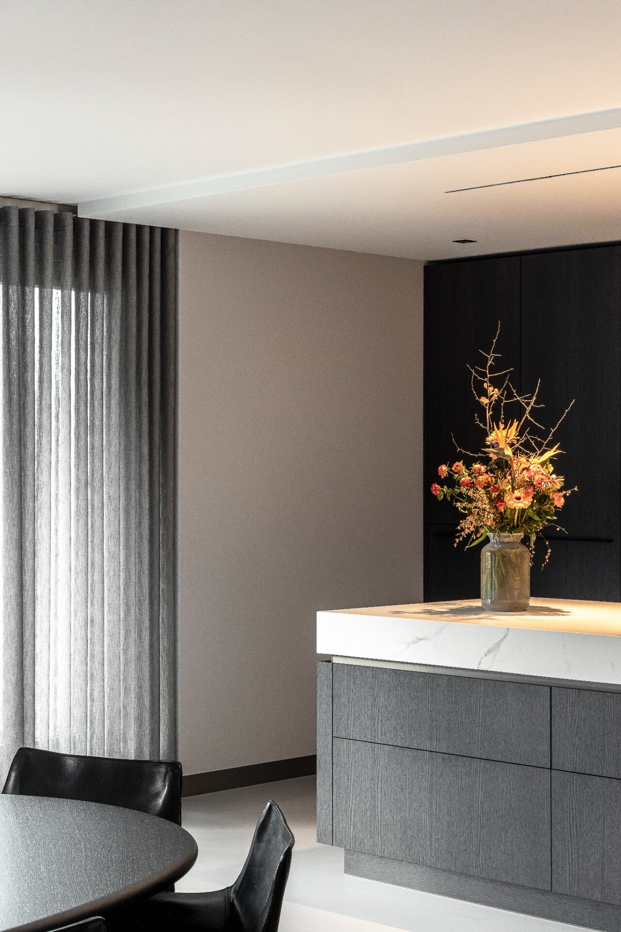 cucina minimalista moderna: zona pranzo con tavolo rotondo e sedie in pelle accanto a cucina in legno scuro, Luxe, Design, Exclusief, Modern, Maatwerk, Bijzondere, Mooie