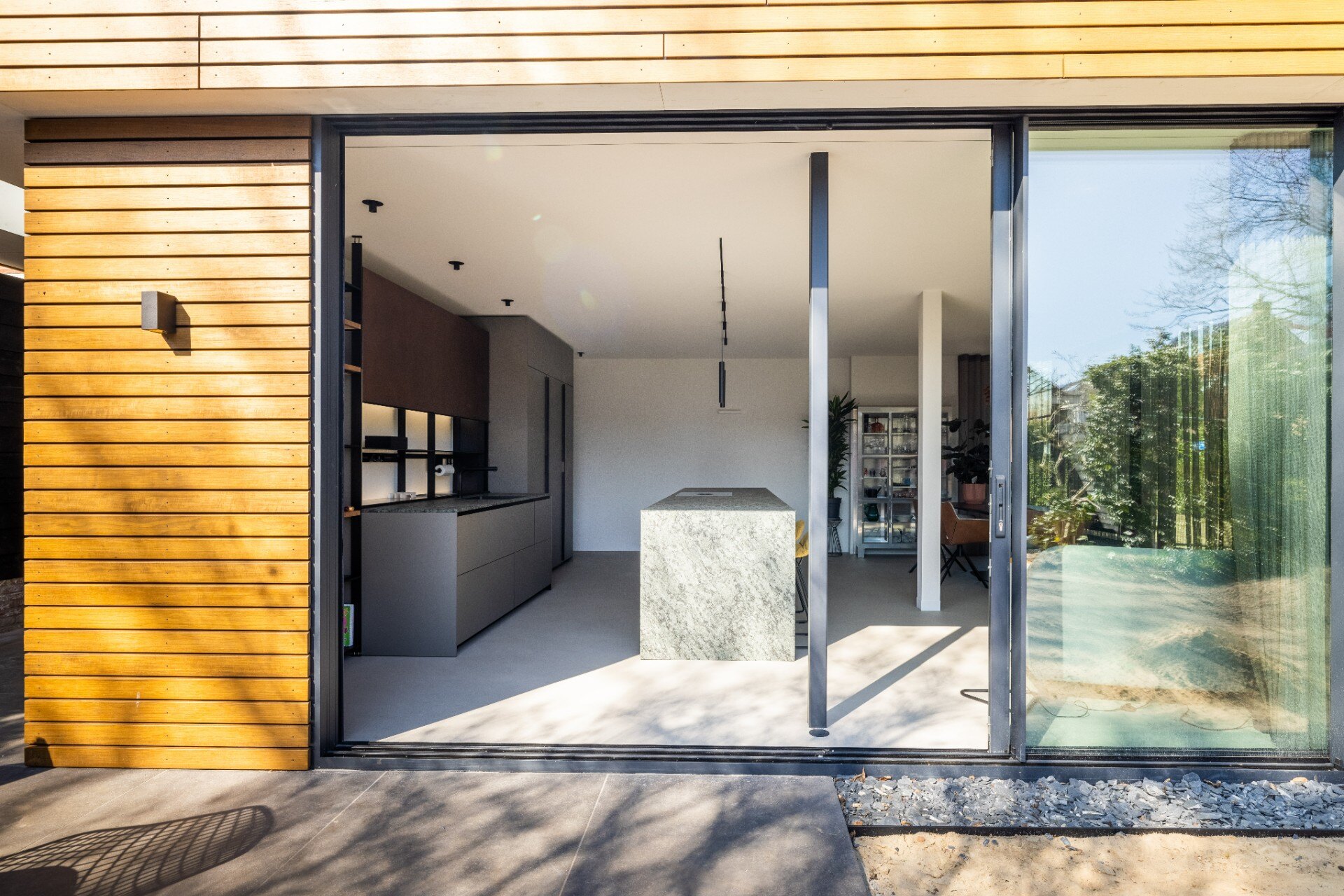 rivestimento in legno per pareti: cucina aperta moderna con grande isola in pietra naturale e porte scorrevoli in vetro, Luxury, Design, Exclusive, Modern, Custom Made, Special, Beautiful