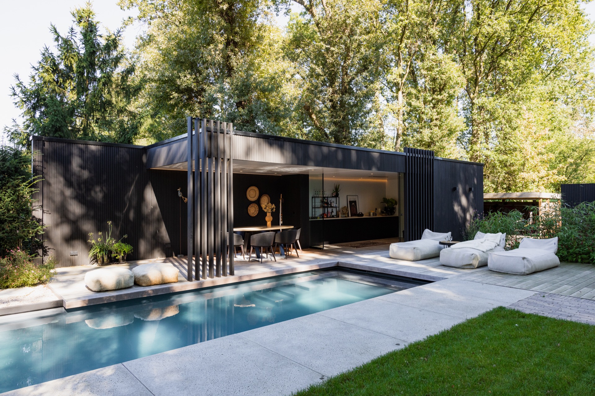 rivestimento in legno per pareti: giardino con piscina blu e dependance in legno nero con zona pranzo aperta circondata dal, Luxury, Design, Exclusive, Modern, Custom Made, Special, Beautiful