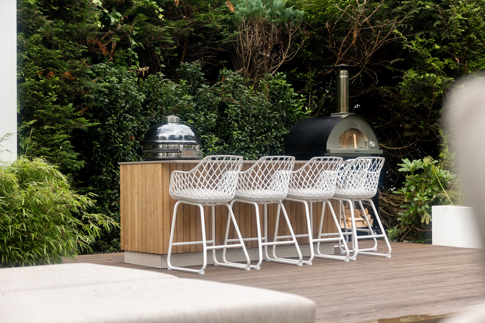 cucina esterna legno: cucina esterna in legno moderna con sgabelli bianchi e barbecue in metallo in giardino verde, Luxury, Design, Exclusive, Modern, Custom Made, Special, Beautiful