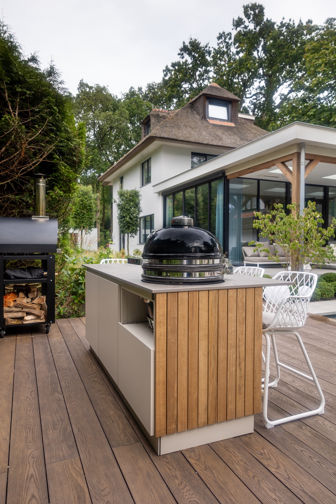 cucina esterna legno: isola cucina esterna con pannelli in legno, griglia in ceramica nera e sgabelli bianchi su terrazza in, Luxury, Design, Exclusive, Modern, Custom Made, Special, Beautiful