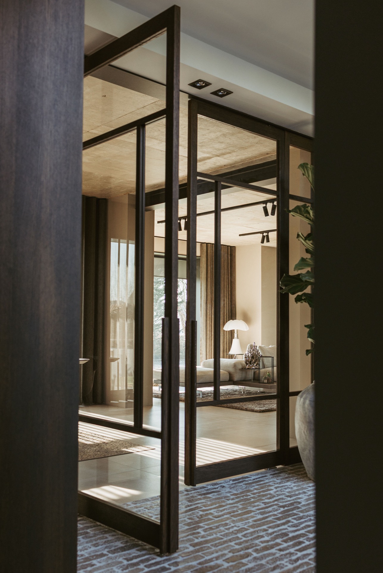 porte pivot in rovere interno: porta pivotante in vetro con telaio in legno scuro e soffitto in cemento in soggiorno luminoso, Luxe, Design, Exclusief, Modern, Maatwerk, Bijzondere, Mooie