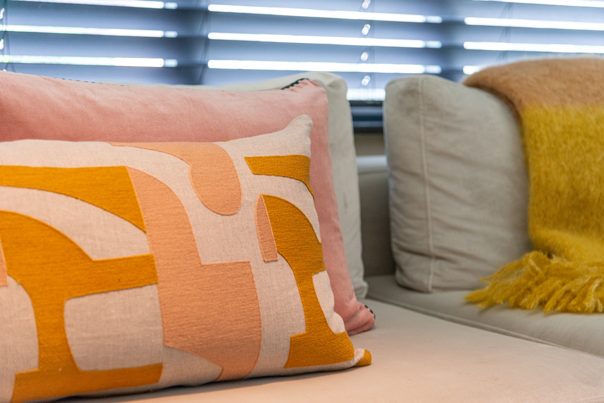 rivestimento in legno per pareti: primo piano di cuscini grafici e coperta giallo senape sul divano, Luxe, Design, Exclusief, Modern, Maatwerk, Bijzondere, Mooie
